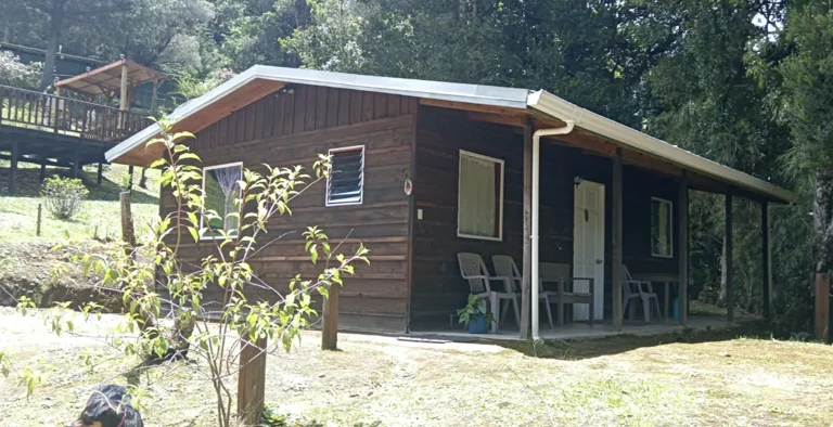Renovated wooden lodge with chairs on a covered porch